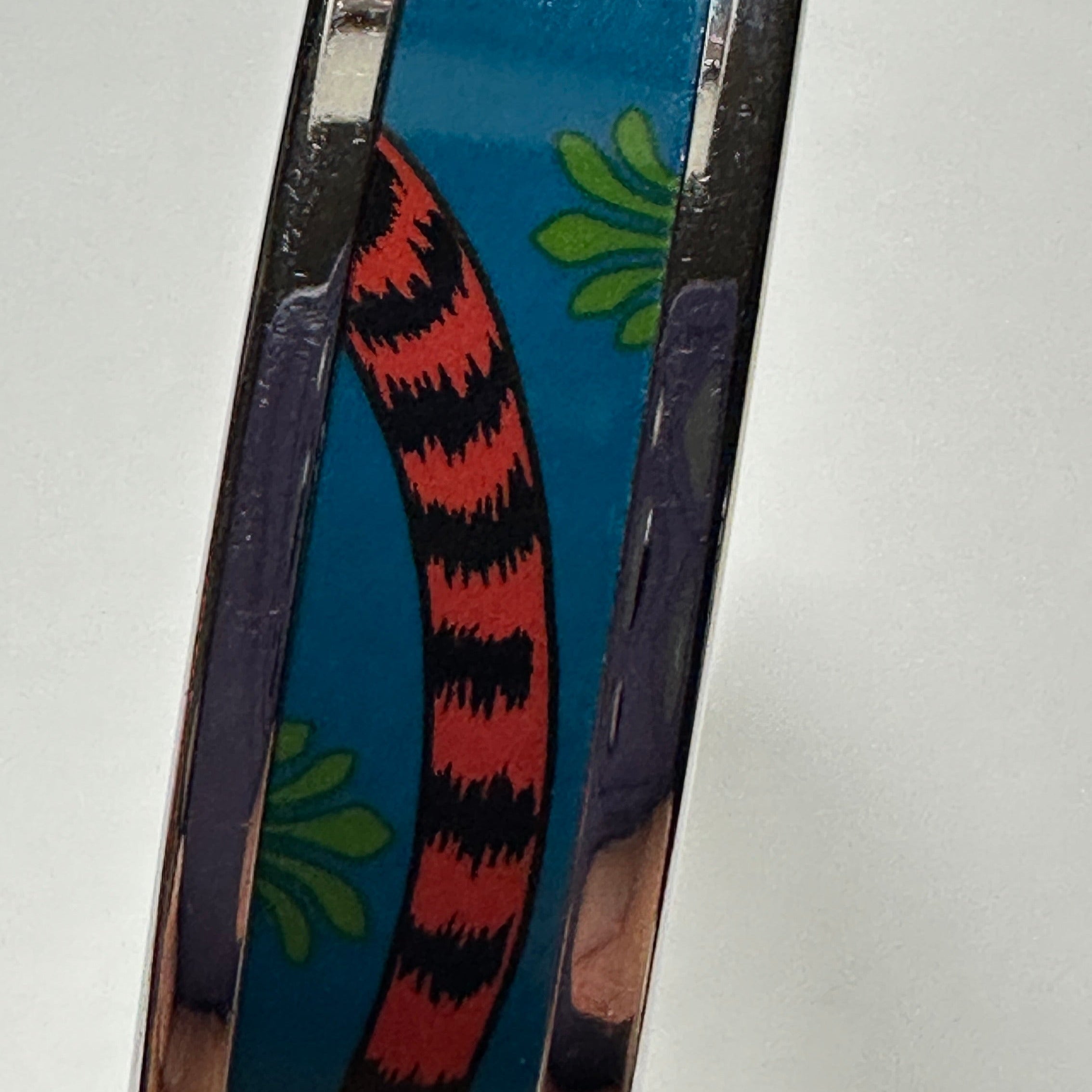 détail queue du tigre inspiré du foulard carré Hermès Tigre Royal sur le bracelet jonc en email Hermès