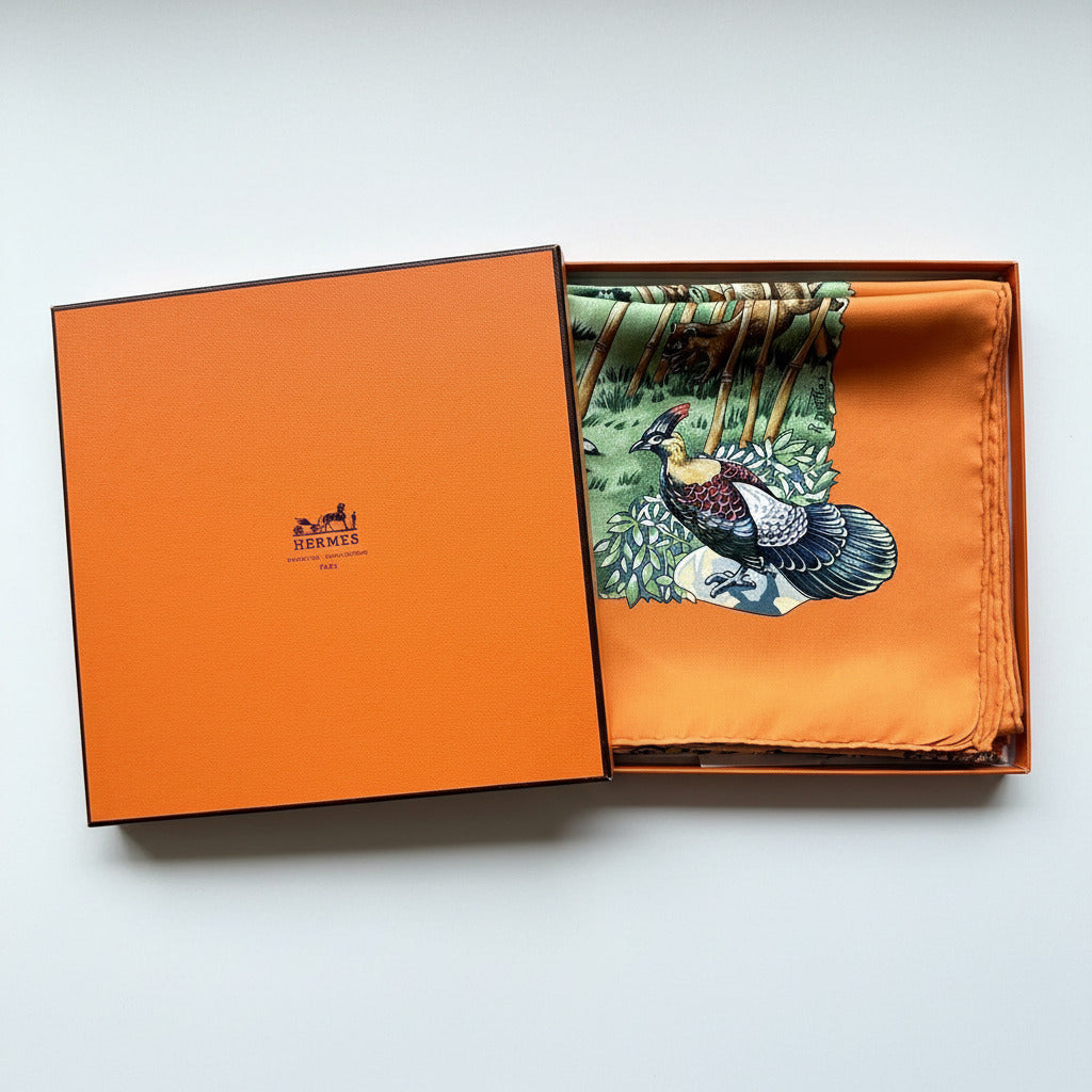 Carré Hermès Sichuan avec boîte : foulard soigneusement plié dans sa boîte orange Hermès d’origine.